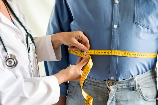 Bariatric Surgeon Measuring Belly of an Obese Patient